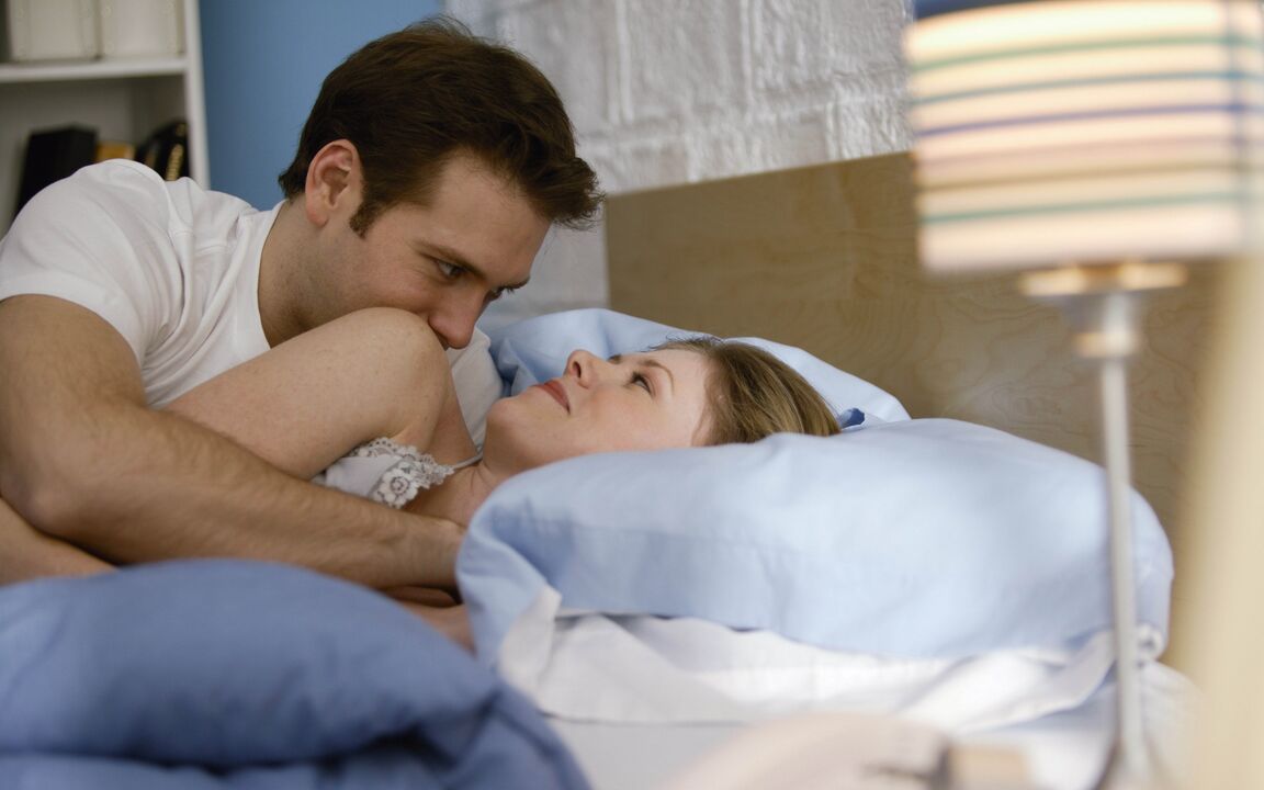 A woman and a man with an enlarged penis in bed